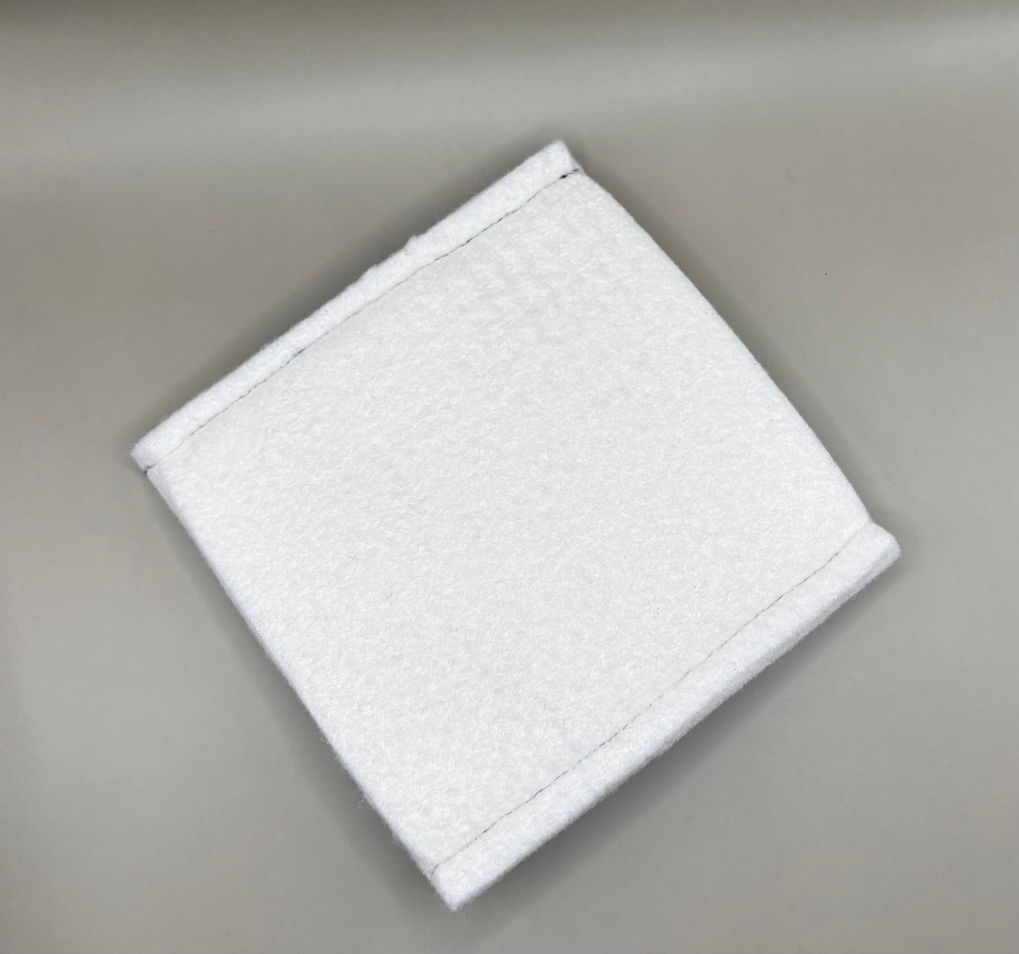 Plush pressing pad with light tan pad and black strap, thick design for everyday hair pressing, suitable for fine to thick hair textures.