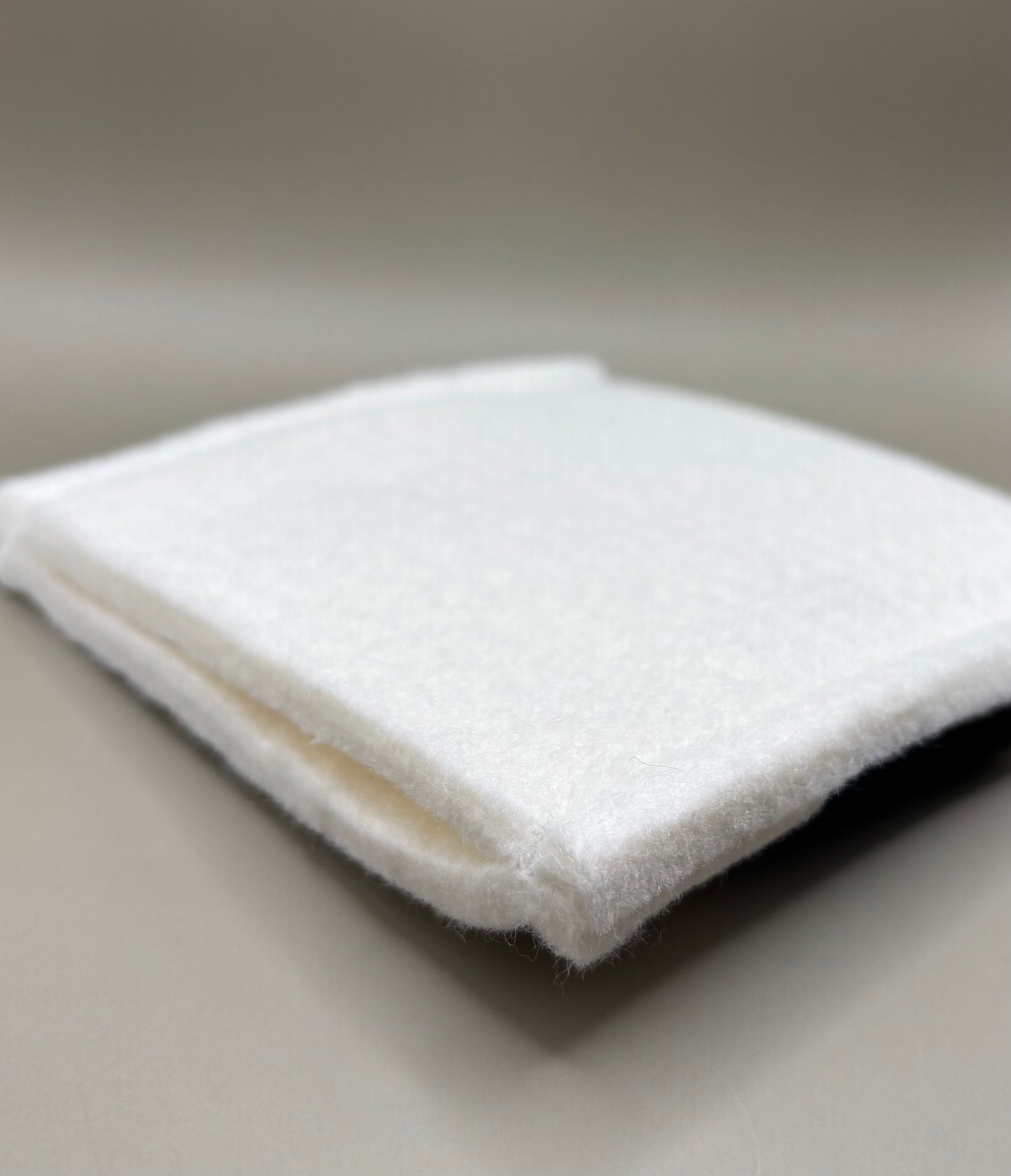 Plush pressing pad with light tan pad and black strap, thick design for everyday hair pressing, suitable for fine to thick hair textures.