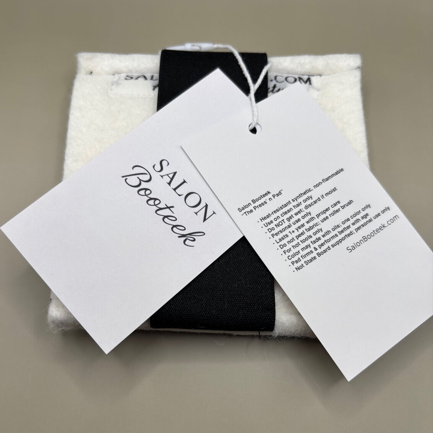 Plush pressing pad with light tan pad and black strap, thick design for everyday hair pressing, suitable for fine to thick hair textures.