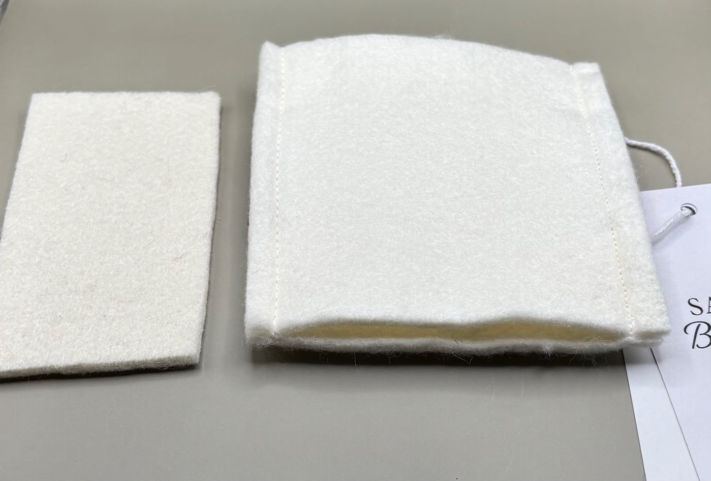 Thin pressing pad with light tan pad and black or burgundy strap, includes inner liner for gentle pressing, ideal for fine hair and smooth glide styling.