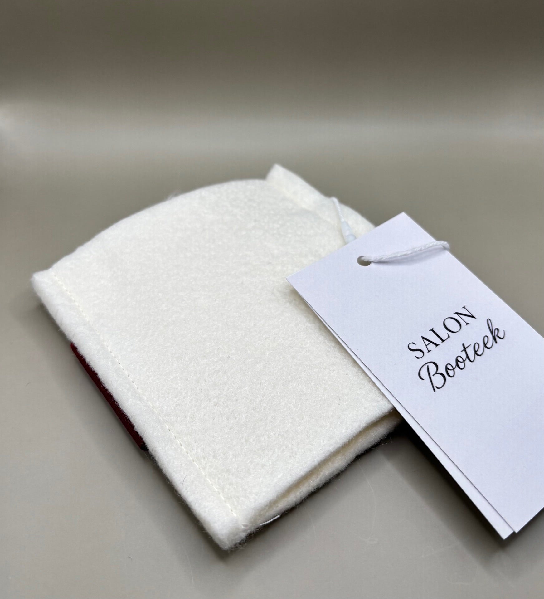 Thin pressing pad with light tan pad and black or burgundy strap, includes inner liner for gentle pressing, ideal for fine hair and smooth glide styling.